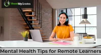 A female remote learner smiling while studying at her desk. Mental Health Tips for Remote Learners.